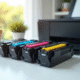 Quatre cartouches de toner colorées sur un bureau lumineux